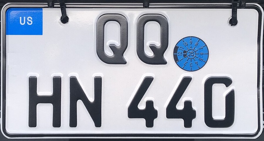 Nahaufnahme eines deutschen Kfz-Kennzeichens mit Prüfplakette